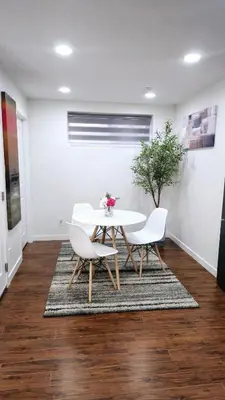 a dining room with a table and chairs on a rug at Cozy & Spacious 1-Bedroom SW Calgary near SpruceMeadows in Calgary