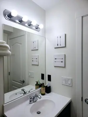 a white bathroom with a sink and a mirror at Cozy & Spacious 1-Bedroom SW Calgary near SpruceMeadows in Calgary