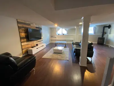 a living room with black furniture and a flat screen tv at 1Bed Cozy Retreat & Spacious Lounge in Yellowknife