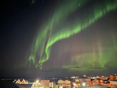 an aurora in the sky over a city at night at 1Bed Cozy Retreat & Spacious Lounge in Yellowknife
