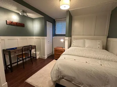 a bedroom with a bed and a desk and a table at 1Bed Cozy Retreat & Spacious Lounge in Yellowknife