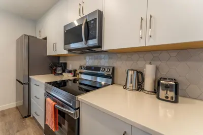 a kitchen with a stove and a microwave at Skyridge by Canmore Premier in Canmore