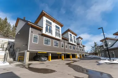 a building with a car parked in a parking lot at Skyridge by Canmore Premier in Canmore
