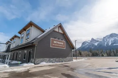 a sign on the side of a building with mountains at Skyridge by Canmore Premier in Canmore