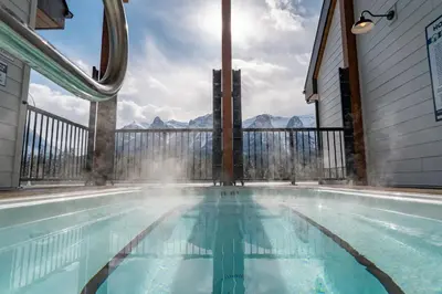 a swimming pool with a view of the mountains at Skyridge by Canmore Premier in Canmore