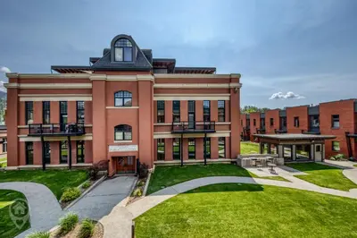 a large brick building with a grass courtyard at 901 Fernie by StayIn in Fernie