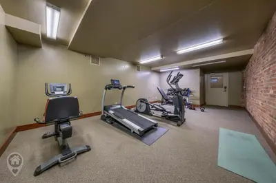 a gym with three exercise bikes and a brick wall at 901 Fernie by StayIn in Fernie