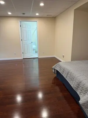 a bedroom with a bed and a wooden floor at Home Away from Home in Calgary