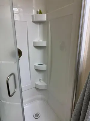 a white bathroom with a shower and a sink at Home Away from Home in Calgary