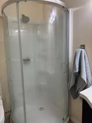 a shower with a glass door in a bathroom at Home Away from Home in Calgary