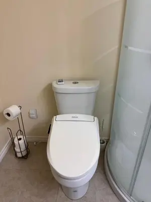 a bathroom with a white toilet and a shower at Home Away from Home in Calgary