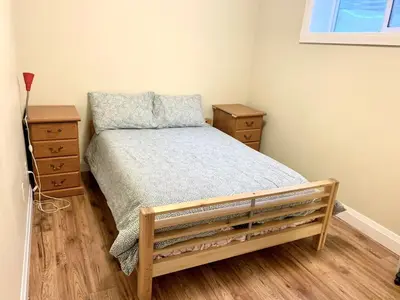 a small bedroom with a bed and two night stands at Spacious 6 beds 3 baths home in Central WiFi parking AC in Edmonton
