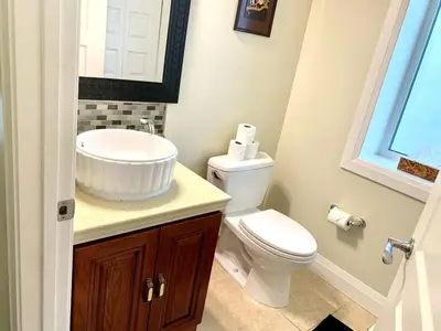 a bathroom with a white toilet and a sink at Spacious 6 beds 3 baths home in Central WiFi parking AC in Edmonton