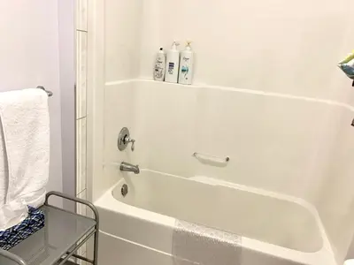 a white bath tub with two shampoo bottles on top of it at Spacious 6 beds 3 baths home in Central WiFi parking AC in Edmonton