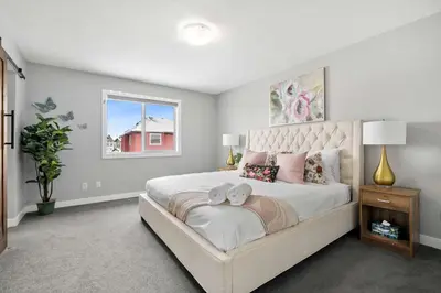 a bedroom with a large bed and a window at Large Family 4BR w Kid's Play Den! FREE Banff Pass in Calgary