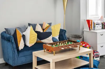 a blue couch with pillows and a table at Large Family 4BR w Kid's Play Den! FREE Banff Pass in Calgary