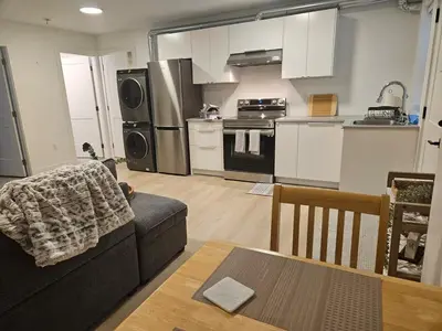 a living room with a couch and a kitchen at Cozy new Suite in Silver Valley in Maple Ridge District Municipality