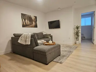 a living room with a couch and a tv at Cozy new Suite in Silver Valley in Maple Ridge District Municipality