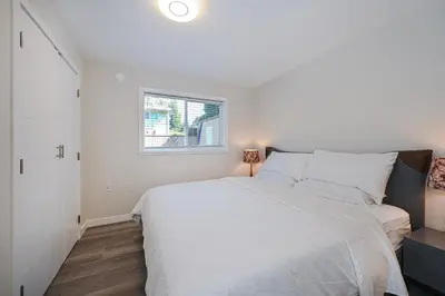 a bedroom with a white bed and a window at Cozy Home with 3BR 4Bath near Richmond Steveston Village in Richmond