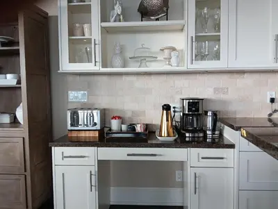 a kitchen with white cabinets and a counter top at Sand and Salt Bed & Breakfast in White Rock
