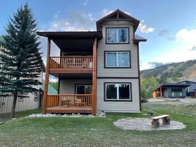 a large house with a deck on a yard at Stemwinder Duplex Chalet by StayIn in Kimberley
