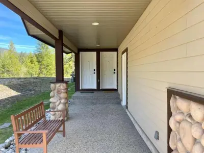 a porch of a house with a bench and a fireplace at Stemwinder Duplex Chalet by StayIn in Kimberley