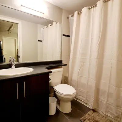 a bathroom with a white toilet and a sink at Charming Abode Downtown Vancouver in Vancouver