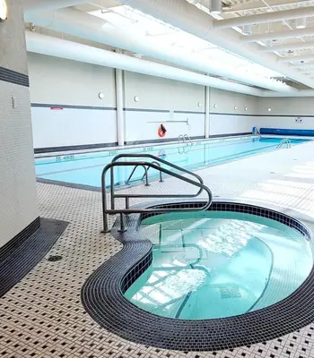 a large swimming pool with a metal pooliterator in a building at Charming Abode Downtown Vancouver in Vancouver