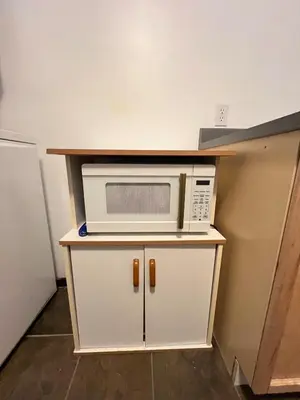 a microwave sitting on top of a white cabinet at Moonlight Stay Downtown Whitehorse in Whitehorse