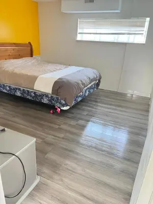 a bedroom with a bed and a wooden floor at Surrey central house in Surrey