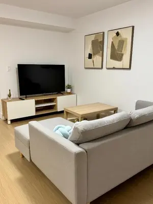 a living room with a couch and a flat screen tv at Levida Living - Cozy 2 Bedroom Suite at the Heart of Langley in Langley