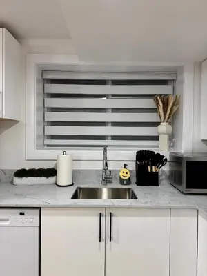a white kitchen with a sink and a window at Levida Living - Cozy 2 Bedroom Suite at the Heart of Langley in Langley