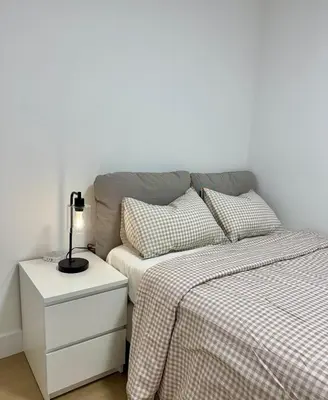 a bedroom with a bed and a lamp on a night stand at Levida Living - Cozy 2 Bedroom Suite at the Heart of Langley in Langley