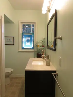 a bathroom with a sink and a mirror and a toilet at Campbell Cottage B&B in Nanaimo