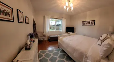 a bedroom with a white bed and a window at Campbell Cottage B&B in Nanaimo