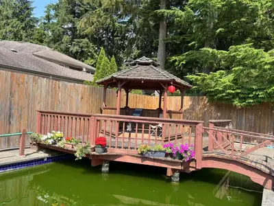a wooden bridge with a gazebo in the water at Rosehouse 2Bedrooms sleep 4 2nd floor private bathroom in Coquitlam