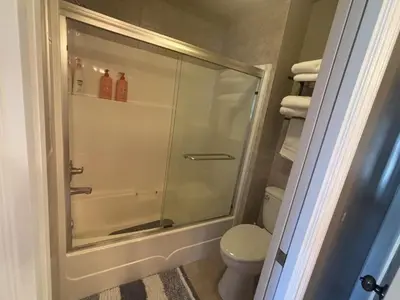 a bathroom with a shower with a toilet and towels at Rosehouse 2Bedrooms sleep 4 2nd floor private bathroom in Coquitlam