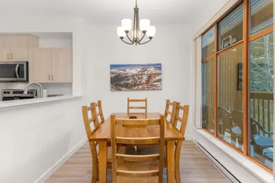 a kitchen and dining room with a wooden table and chairs at Whistler Village Condo Sleeps 7 in Whistler
