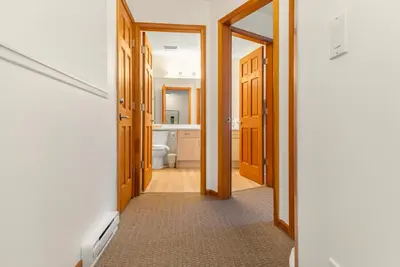 a hallway with a bathroom with a toilet and a mirror at Whistler Village Condo Sleeps 7 in Whistler