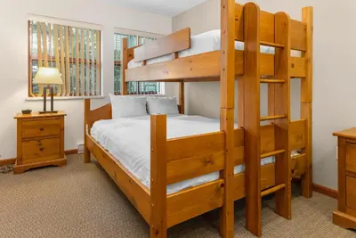 a bedroom with two bunk beds and a desk at Whistler Village Condo Sleeps 7 in Whistler