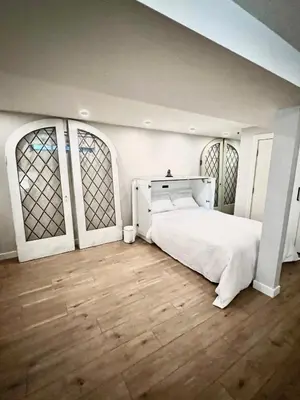 a bedroom with a white bed and two windows at 3 level, home near downtown! in Vancouver