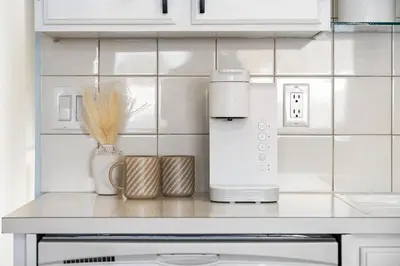 a kitchen with a counter with a coffee maker and a appliance at Silver Springs Family Retreat in Calgary