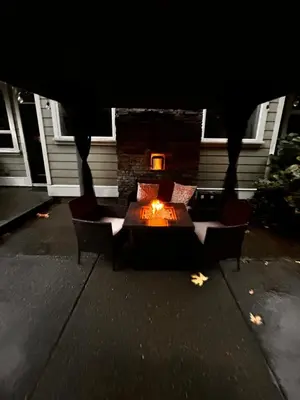 a patio with a table and chairs and a fireplace at Charming scape by Bear Mountain in Victoria