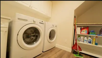 a white washer and dryer in a laundry room at Charming scape by Bear Mountain in Victoria