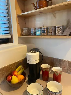 a kitchen counter with a coffee maker and a bowl of fruit at Pika's Place Bed and Breakfast in Canmore