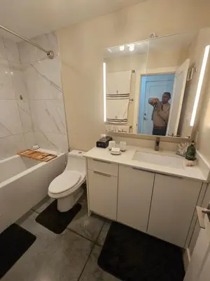 a man taking a picture of a bathroom at The Ridge in North Vancouver