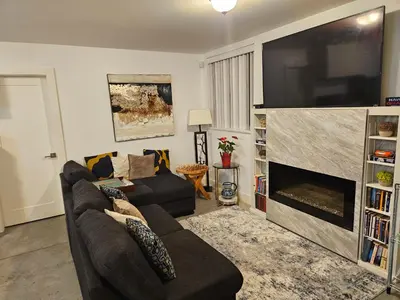 a living room with a couch and a large flat screen tv at The Ridge in North Vancouver