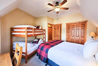 a bedroom with two bunk beds and a ceiling fan at Heron Point by StayIn in Invermere