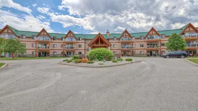 a large building with a parking lot in front of it at Heron Point by StayIn in Invermere