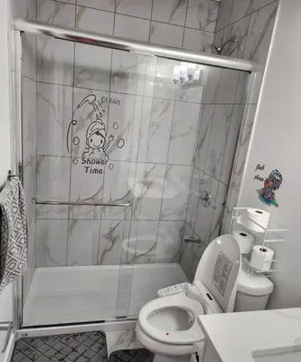 a bathroom with a shower with a toilet and a sink at 2 bedrooms luxury basement suite close to Calgary airport in Calgary